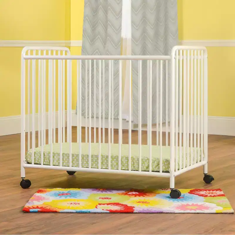 Child Craft Siesta Metal Compact Non-Folding Portable Crib with 2 Crib Mattress and Locking Wheels, Durable Metal Construction, Easy to Clean (White)