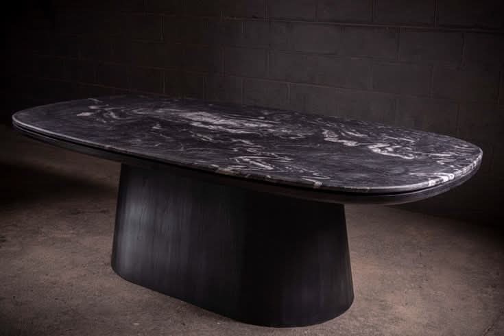 Dining Table - A study in contrast — the leathered quartzite top carries a tactile depth that shifts with the light, anchored by a black matte...