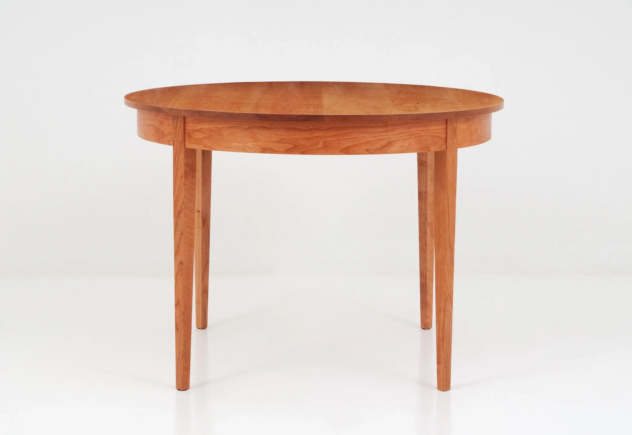 Round Table - The graceful curves and rich grain patterns of the Round Table add a touch of formality and beauty to any