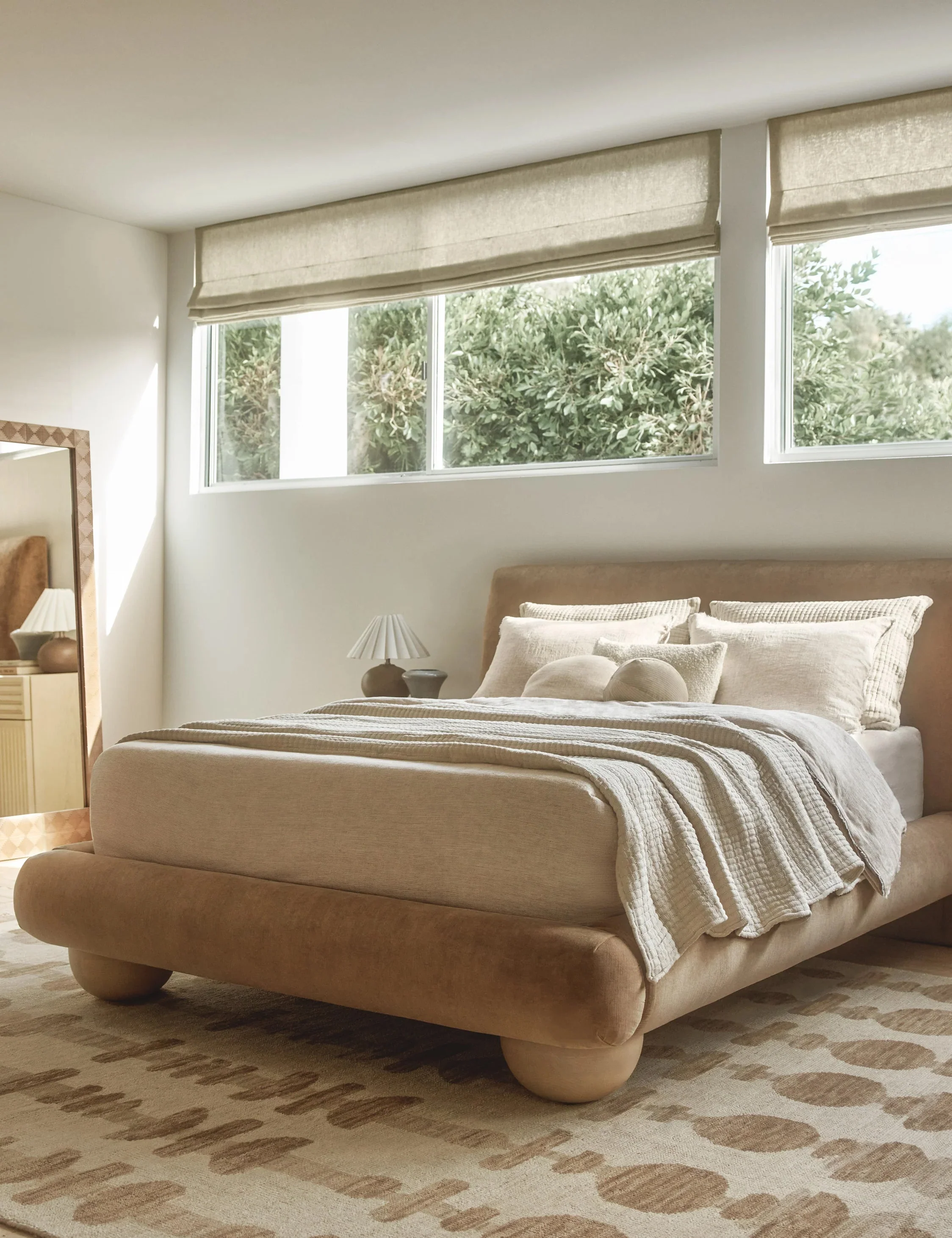 Bed Soft lines bring a modern silhouette to the bed. Oversized bun feet float the upholstered bed frame with a grounding touch of light wood grain