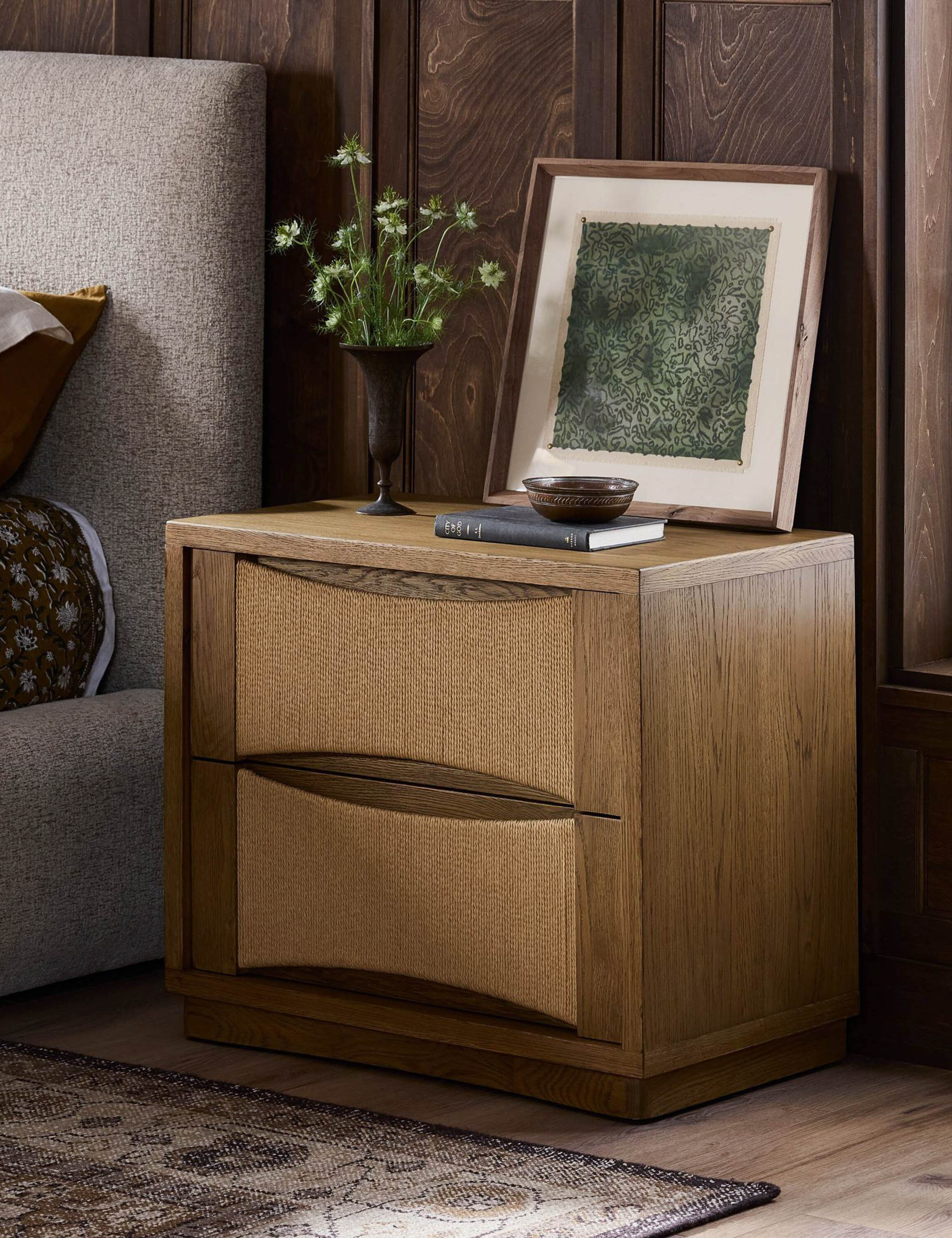 Nightstand - Warm oak framing and woven drawer fronts add natural depth and texture to the nightstand