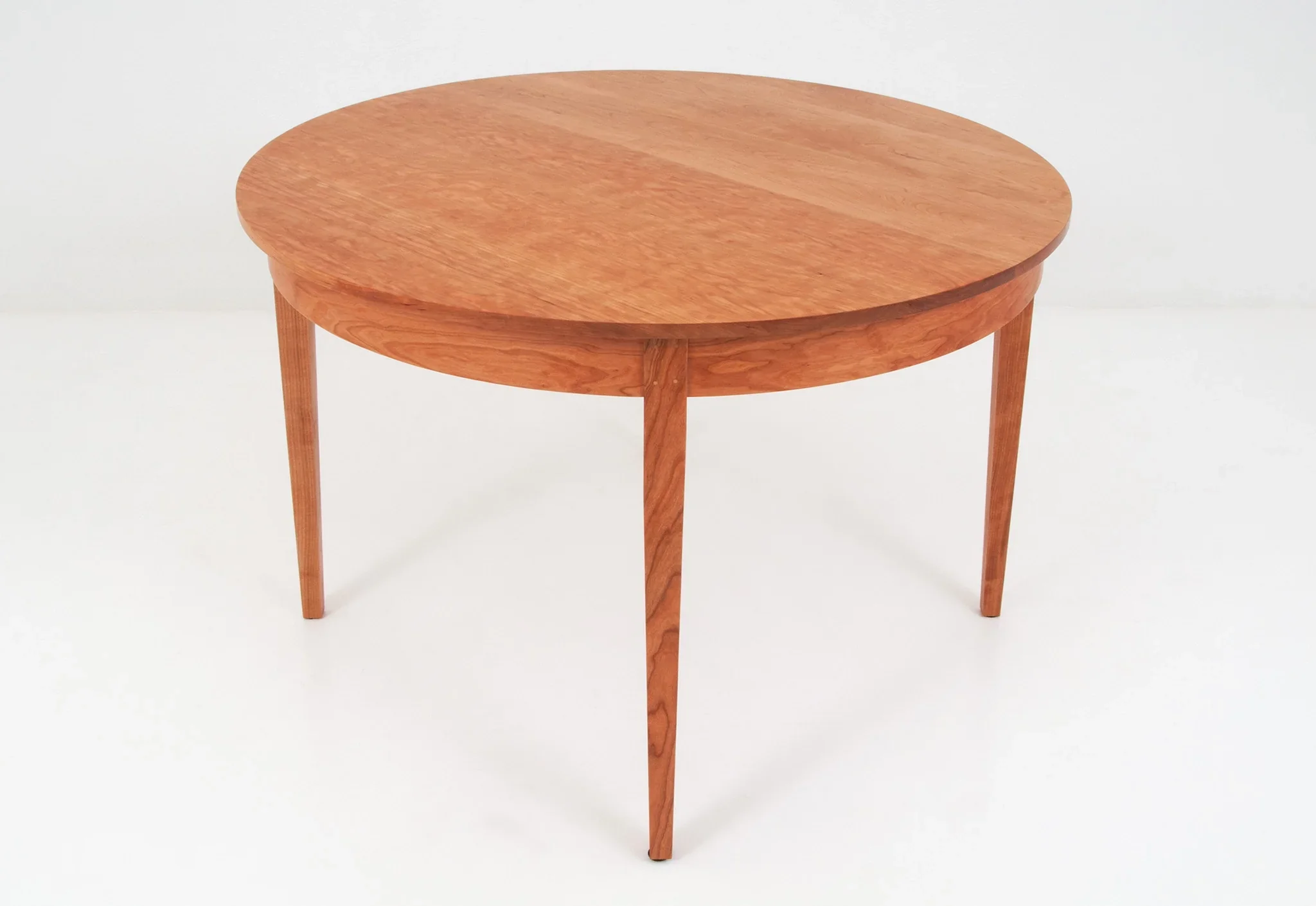 Round Table - The graceful curves and rich grain patterns of the Round Table add a touch of formality and beauty to any
