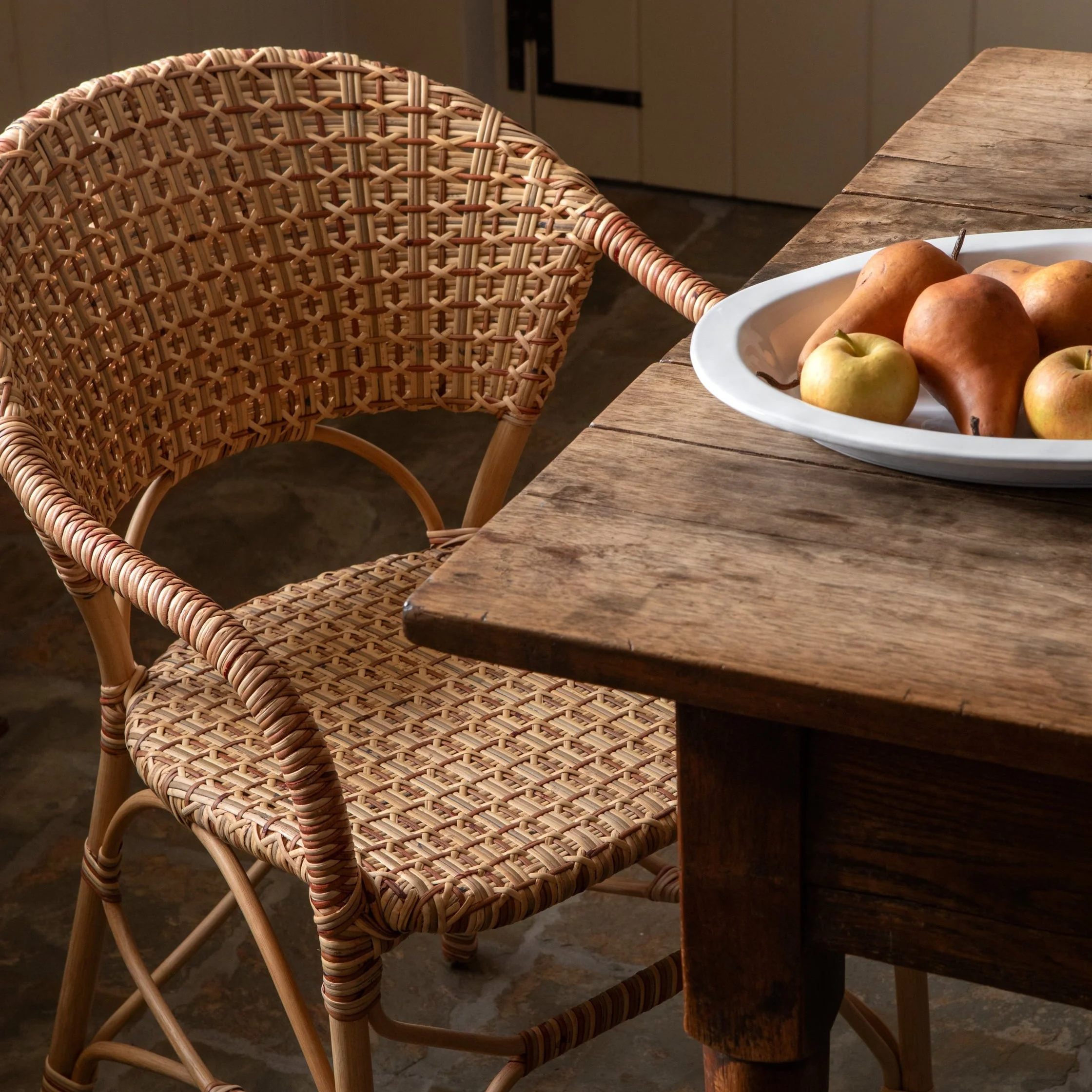 Arm Chair - handwoven from sustainably sourced rattan, its earthy palette and elegant silhouette bring timeless style to both casual kitchens and...